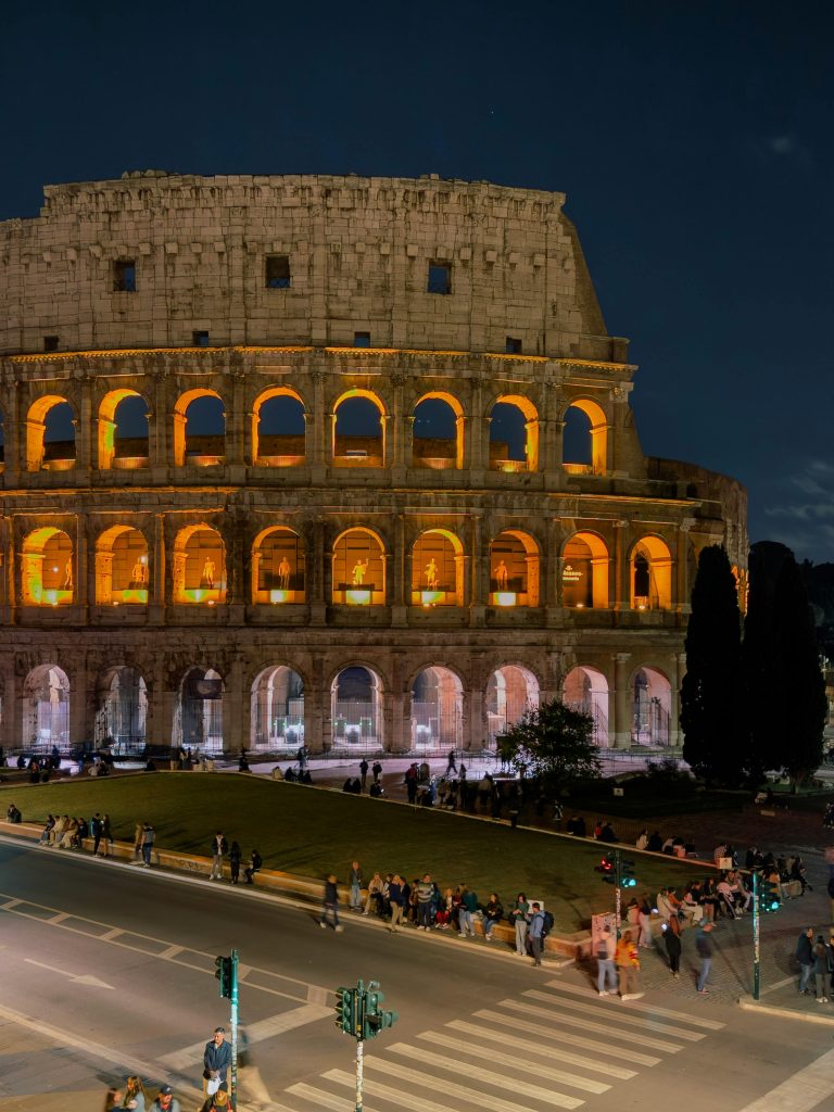 Stunning night view of the illuminated Colosseum in Rome, showcasing its ancient architecture.
